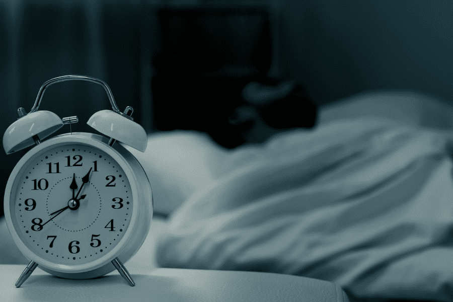 Man Sleeping Next to Alarm Clock